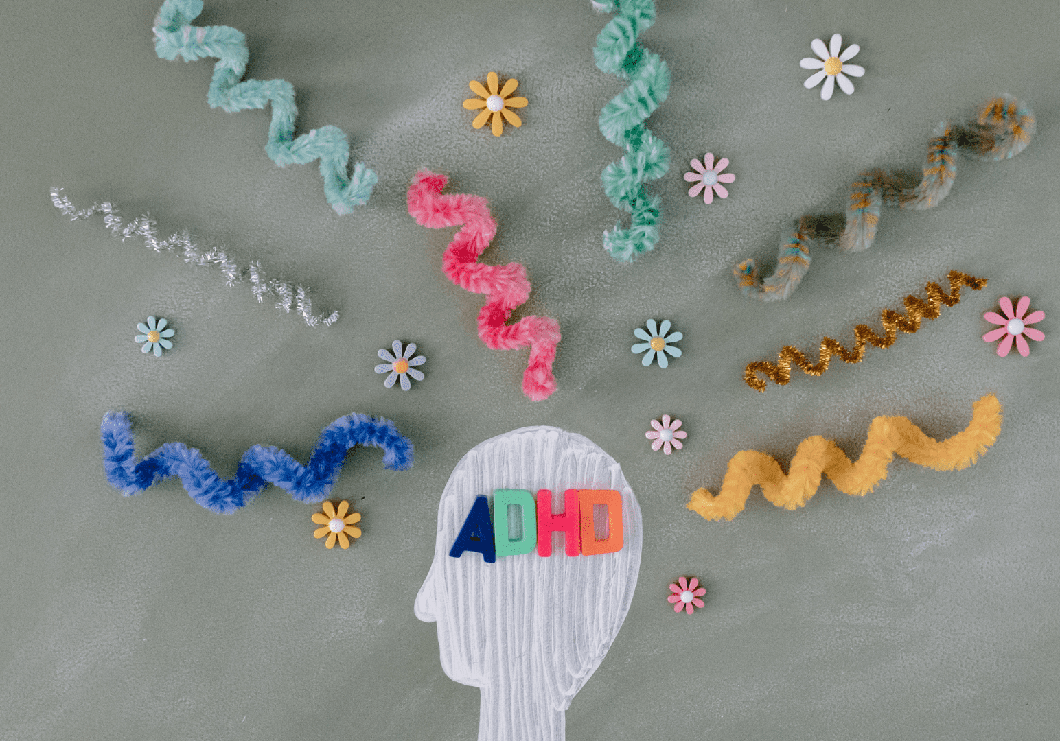 A head with the word adhd written on it surrounded by colorful yarn.